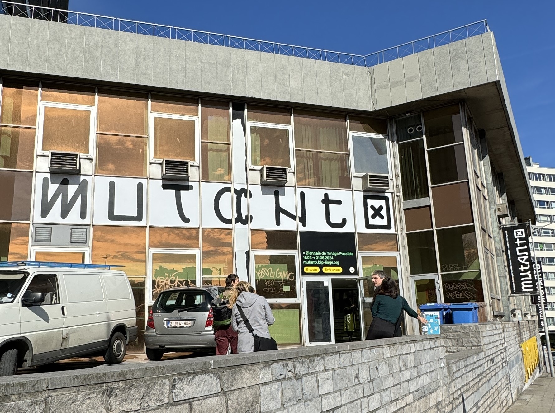 Blick auf den Eingang zum Hauptquartier der Biennale in Lüttich. Auf einem Banner steht Mutantx