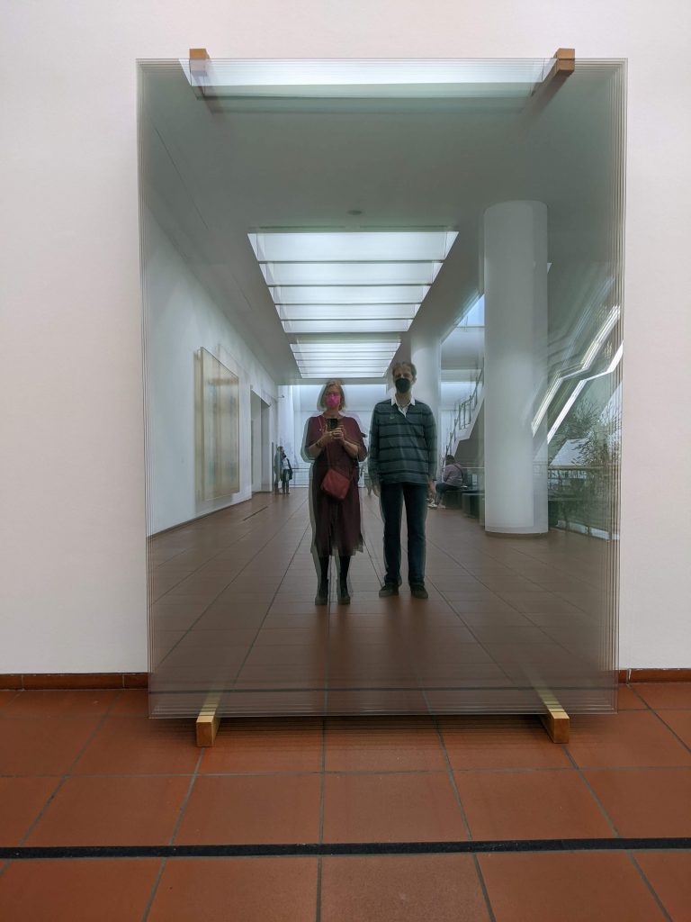 Ein Paar spiegelt sich in den Glasscheiben von Gerhart Richter, die im Treppenhaus des Museums Ludwig aufgestellt sind. 